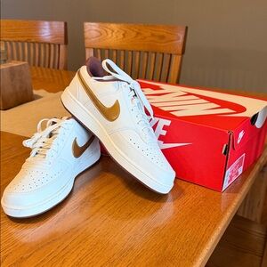 Nike women’s Low-Top Sneakers in White with Gold Swoosh